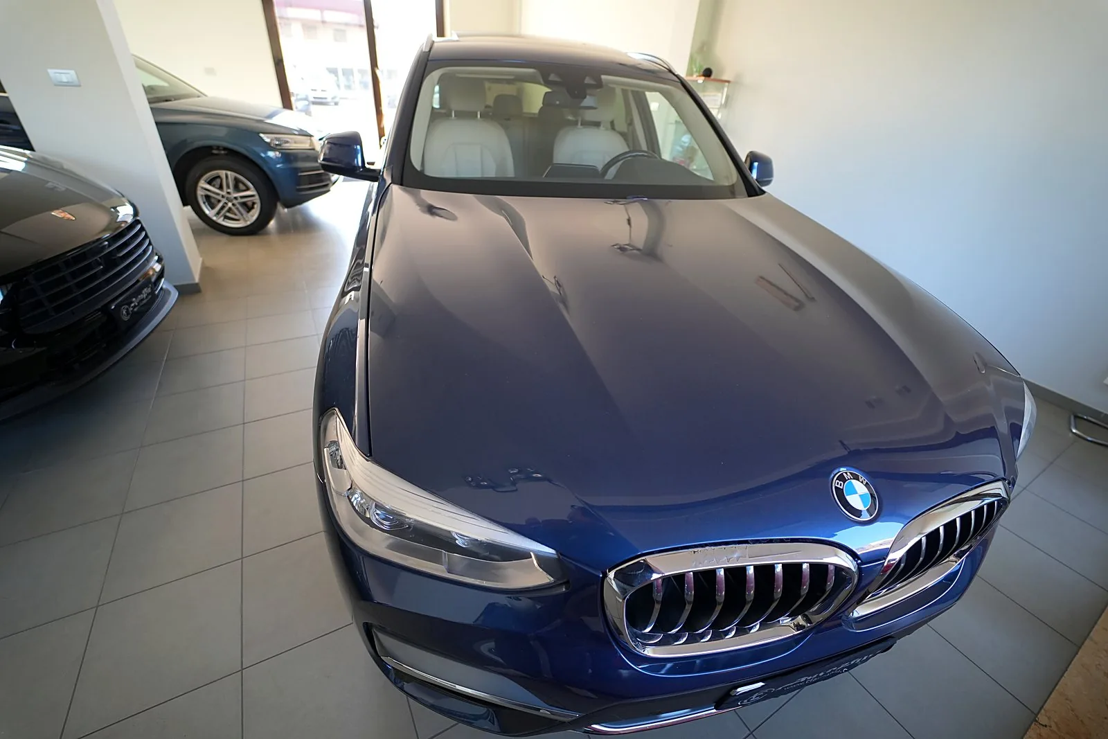 Il frontale di una berlina blu esposta nel salone AutoPiù